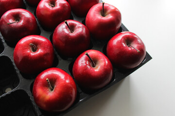 Perfect Red Apple Fruits In Separated Places Of Black Plastic Box 
