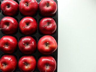 Plastic Tray With Fresh Red Apples On White Surface At A Side Of Image
