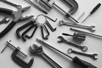 Variety scattered hand tools on a white shelf. Monochrome stock photo for repairing backgrounds
