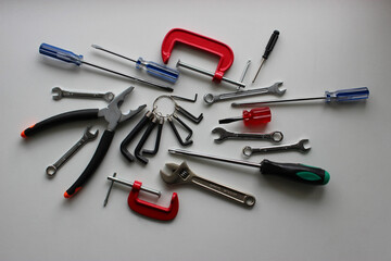 Chaotically scattered colored hand tools on a white shelf. Stock photo for DIY and repairing illustration 
