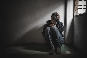 Asian man addict drug in the deserted place,A junkie feels alone in this world,Sad young man sitting in the corner of the room,People are stressed and have depression