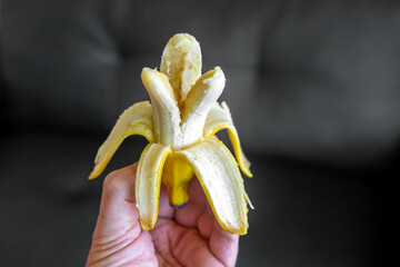Holding a peeled Banana in a non-traditional way, showing the internal parts of the fruit