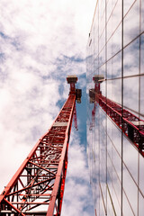 Red crane reflected on glass building 