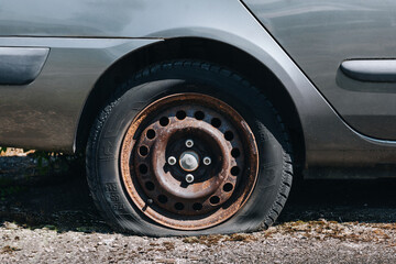 punctured tire in a wheel of a passenger car - obrazy, fototapety, plakaty