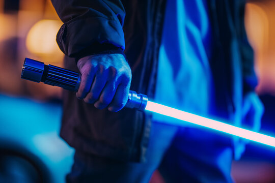 Close up of hand holding Light saber sword technology