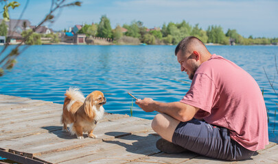 Young man with a little golden Asian dog, pet behavior concept. Human best friend