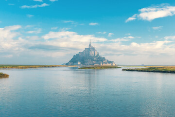 Mont Saint Michel abbey on the island with river at sunrise, Normandy, Northern France, Europe. Tidal island with medieval gothic cathedral in Normandie. Travel and touristic destination