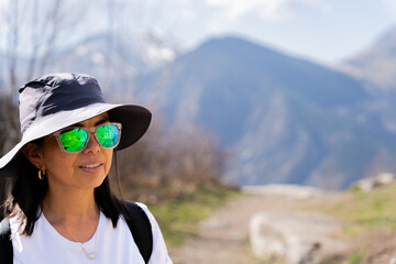 Latin woman hiker enjoying the beautiful views from the top of the mountain on a beautiful day of...