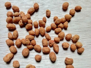Flat lay snacks kacang telor on a wooden background.