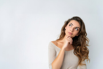 Fototapeta premium Young woman having doubts while looking up