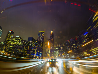 Back car window view of long exposure of the highway in the city. City at night Driving a car, the...