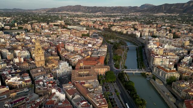 Cinematic aerial view of European city Murcia. Panoramic view of old town. River Segura at right. Cathedral of Murcia at left. Drone going forward above city center.