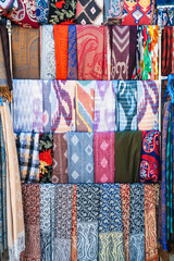 Traditional silk Asian scarves with a bright colorful pattern at the oriental bazaar in Tashkent in...