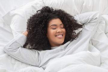 Woman Laying in Bed With Head on Hands in Morning