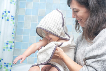 Mother and child smiling as the mother towels the toddler dry.