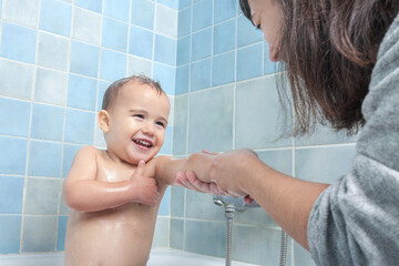 Mother washes her child during bath time.