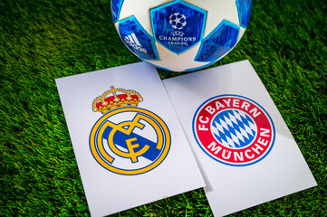 Fototapeta premium Real Madrid (ESP) vs Bayern Munich (GER). Semifinals of football UEFA Champions League 2024 in Europe. Logo of teams and official soccer ball on green grass