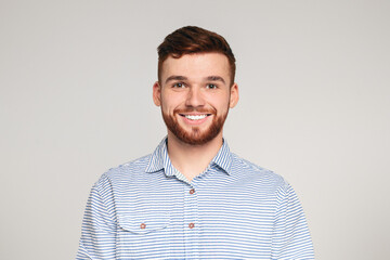 Portrait of smiling millenial guy on beige background
