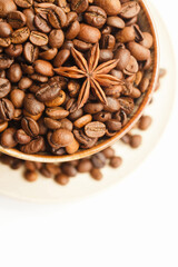 Cup with coffee beans and spices on white background. Top view. Space for a text