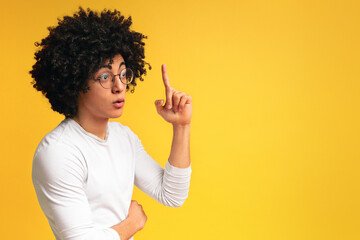 Young african-american man having idea, pointing finger up