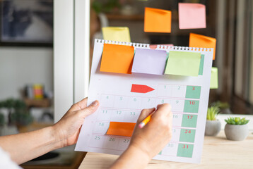 Event Planner Calendar Agenda Plan. Unrecognizable Business Person Taking Note on Calendar Desk at...