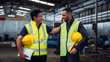 Two men in safety vests are smiling at each other