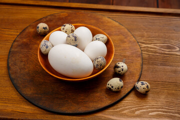 goose chicken and quail egg in a wooden saw on the table
