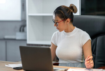 asian beautiful woman focus on business work. busy female worker working overtime try to find information on paper sheet and sticky notes on table. occupation office woman overwork alone at workplace