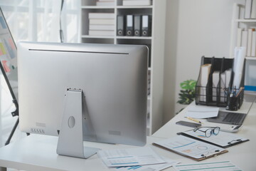 Laptop computer with opened lid on table in meeting room of office workspace.