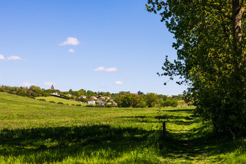 Village de Nailloux avec son église de briques rouges au printemps depuis la coulée verte d’En...