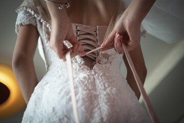 Tying a corset on a bride's dress