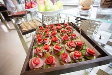 Canapes on wrapped skewers with tomato