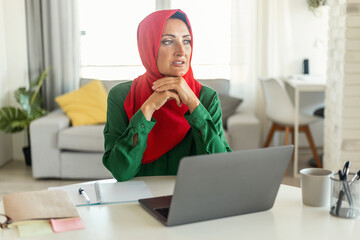 Muslim Woman Sitting at Table With Laptop, Copy Space