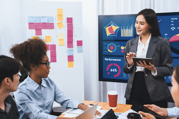 Young asian businesswoman presenting data analysis dashboard on TV screen in modern meeting....