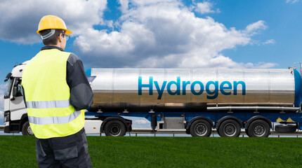 Man with digital tablet on a background of hydrogen tank trailer.