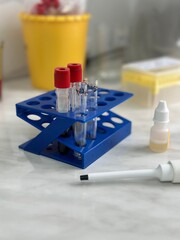 A lab bench with a tray of test tubes and a bottle of yellow liquid.