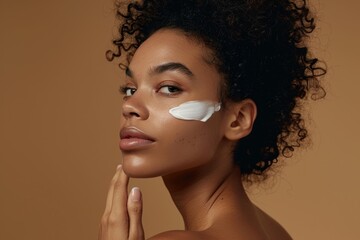 Face, cream, and black woman in studio promotional skincare, beauty, and cosmetics portrait with product application. Skin care, dermatology, and sunscreen wellness in an African model headshot