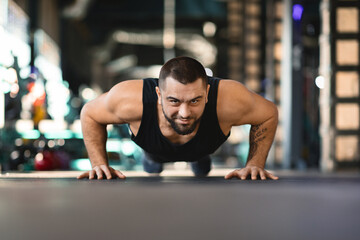Fototapeta premium Man Doing Push Ups in a Gym
