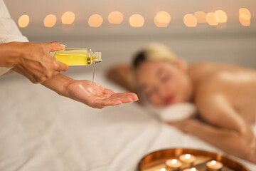 Woman Receiving Massage With Bottle of Oil