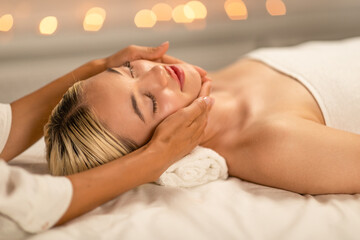 Obraz na płótnie Canvas Serene Lady Receiving Relaxing Facial Massage at a Luxury Spa