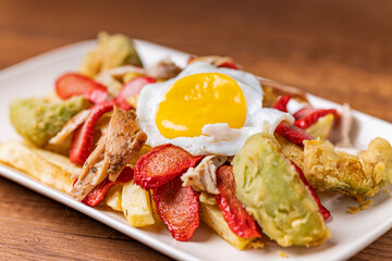 Salchipapa, French fries, hot dog, chicken, egg and crispy avocado.
