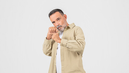 Man in Tan Shirt Holding Hands Together In Fighting Pose