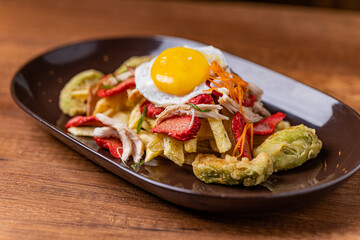 Salchipapa, French fries, hot dog, chicken, egg and crispy avocado.