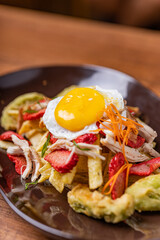 Salchipapa, French fries, hot dog, chicken, egg and crispy avocado.