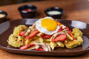 Salchipapa, French fries, hot dog, chicken, egg and crispy avocado.