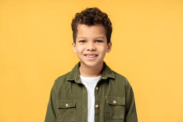 African American boy in casual clothes, posing in studio, isolated on yellow background
