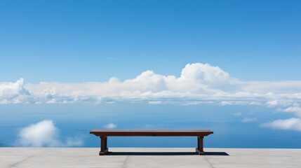 Empty bench overlooking a serene ocean view under a clear blue sky
