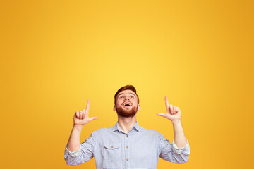Man Raises Hands in Front of Yellow Background