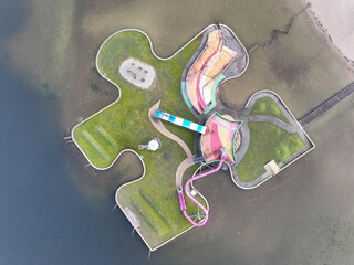 Aerial drone view children playground in the form of a puzzle piece. Colorfull recreation area with...