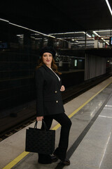 Obraz premium Beautiful lonely girl in black posing in the subway.